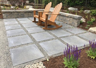 paver and gravel patio area with chairs