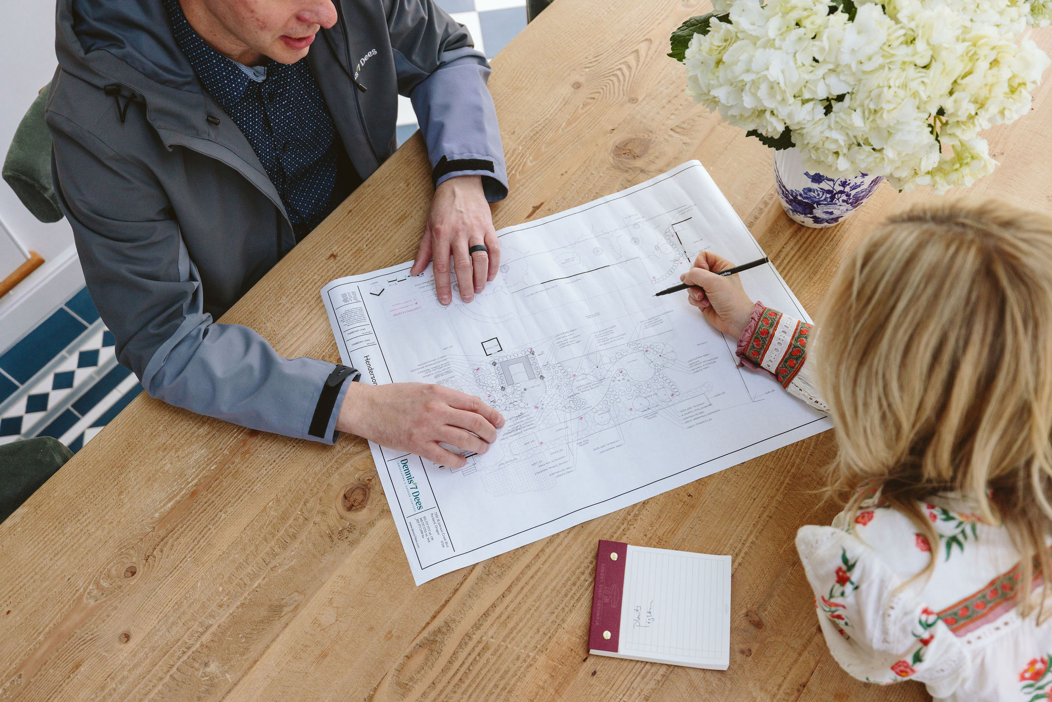 Dennis' 7 Dees Landscape Designer Eric Hagberg and Emily Henderson reviewing a backyard renovation landscape plan Dennis' 7 Dees Landscape Designer Eric Hagberg and Emily Henderson reviewing a backyard renovation landscape plan